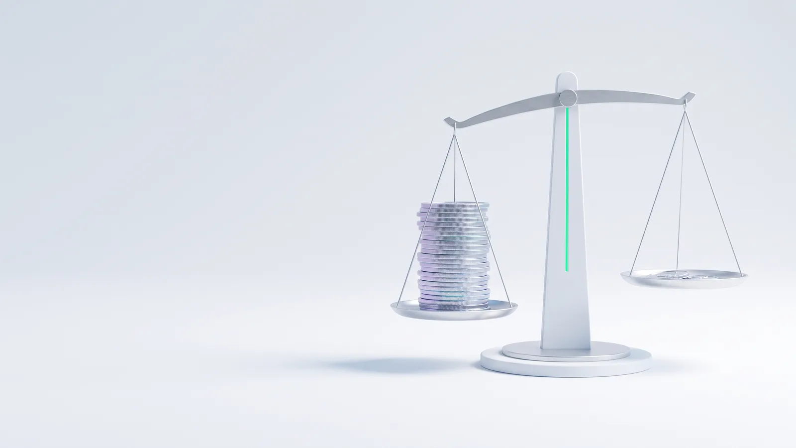 A white balance scale with a stack of silver coins on one pan and the other pan nearly empty.